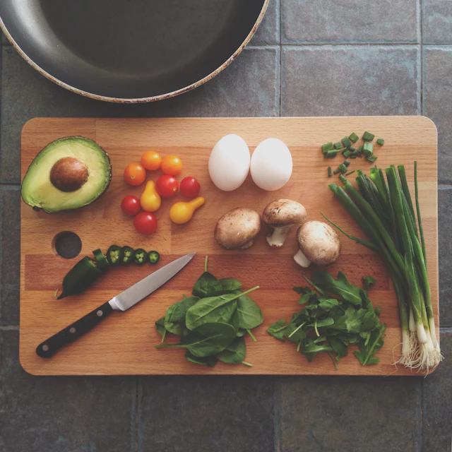 Knife and fresh ingredients laid out on a cutting board